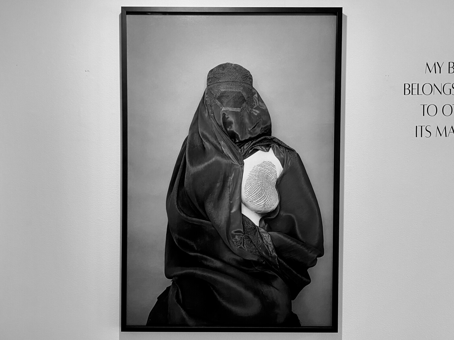 Fotografia de Rada Akbar d’una dona afganesa que mostra un pit enguixat i marcat, en forma d’empremta dactilar, pels textos de l’Alcorà que la reprimeixen.