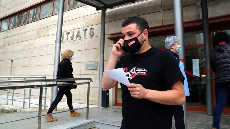 Pla mitjà del regidor de la CUP de Reus Edgar Fernández després de comparèixer als jutjats detingut pels Mossos, amb una acta a la mà. Imatge del 23 de febrer del 2021. Agència Catalana de Notícies