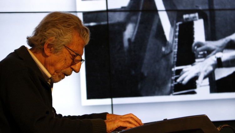 Detall de Francesc Burrull tocant el piano amb una foto seva antiga. Agència Catalana de Notícies