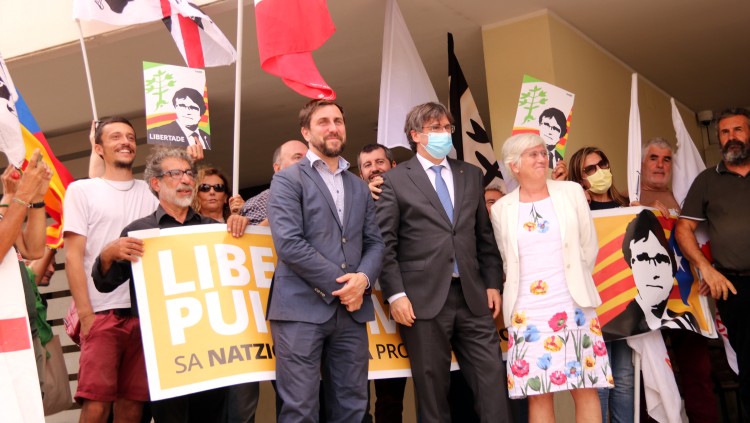 Puigdemont, Comín i Ponsatí a la sortida del tribunal de Sàsser i davant una pancarta de suport, el 4 d'octubre del 2021. Agència Catalana de Notícies