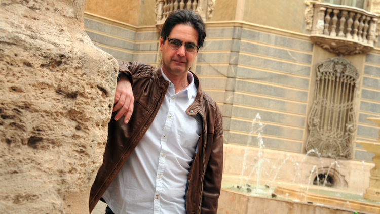 Vicenç Pagès, recolzat a l’església de Sant Joan de la Creu de València, amb el Palau del Marquès de Dosaigües al fons. Prats i Camps
