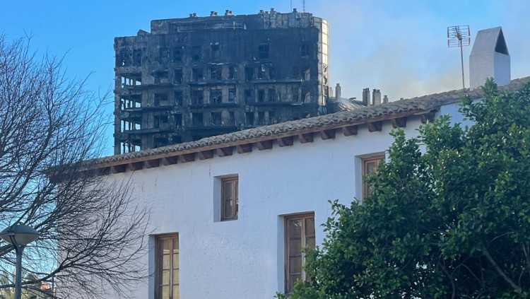 L’alqueria de Ricós, una de les poques que va sobreviure a Campanar, i darrere, l’edifici sinistrat.