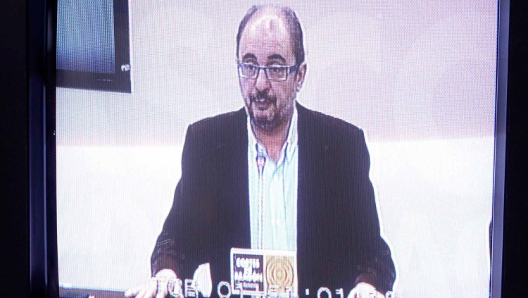 Javier Lambán, vist a través d'una pantalla de televisió en una compareixença pública.. EFE