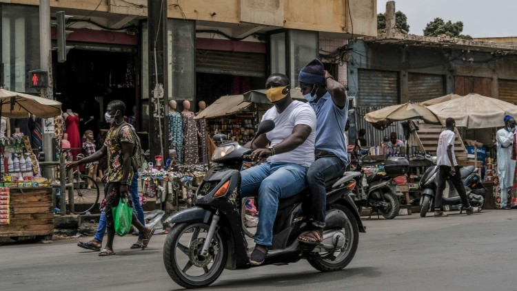 Dos homes amb mascareta viatgen en moto per Dakar, Senegal. Europa Press