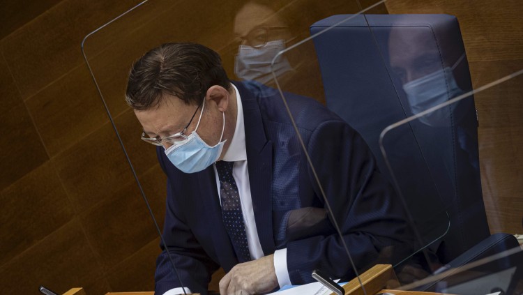 Ximo Puig en una sessió recent de les Corts. Les cares de Mónica Oltra i Rubén Martínez Dalmau es reflecteixen a la mampara protectora.. Miguel Lorenzo